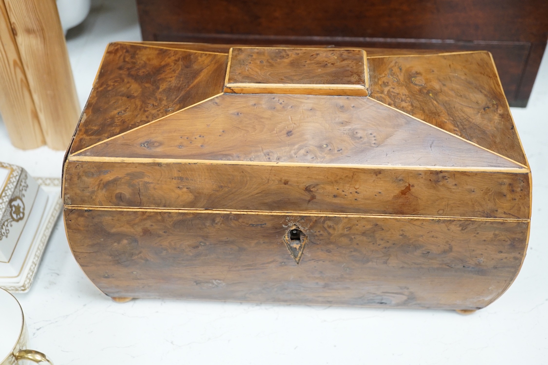 A Victorian boxwood strung burr yew sarcophagus shaped tea caddy, another mahogany tea caddy, a brass bound mahogany silver box with Bramah lock and another mahogany box. Largest 40cm wide